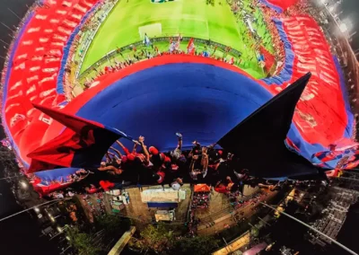 Vista panorámica del estadio de Medellín durante un partido de fútbol con hinchada y banderas