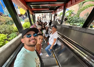 Grupo de turistas en las escaleras eléctricas de la Comuna 13 en Medellín durante un recorrido cultural guiado