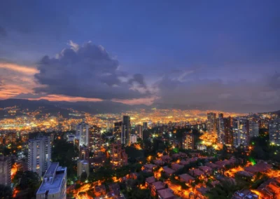 Vista panorámica de Medellín al atardecer con las luces de la ciudad encendidas