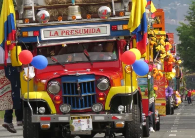 Chiva tradicional en Medellín decorada con globos y banderas de Colombia durante un recorrido festivo