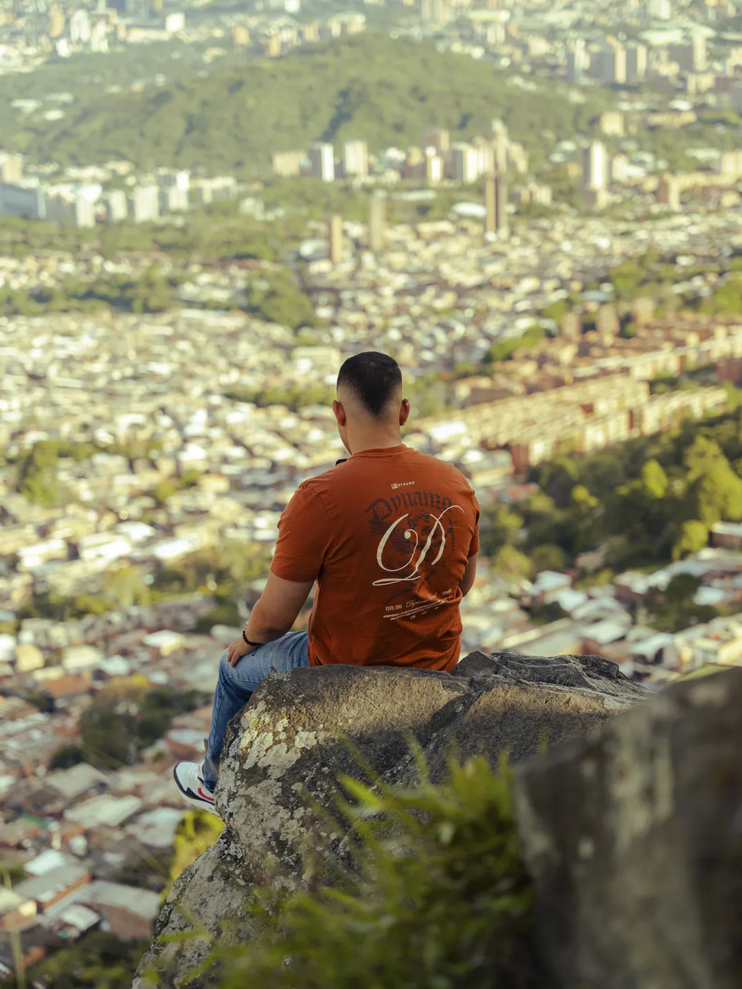 Turista sentado en el mirador El Picacho contemplando Medellín
